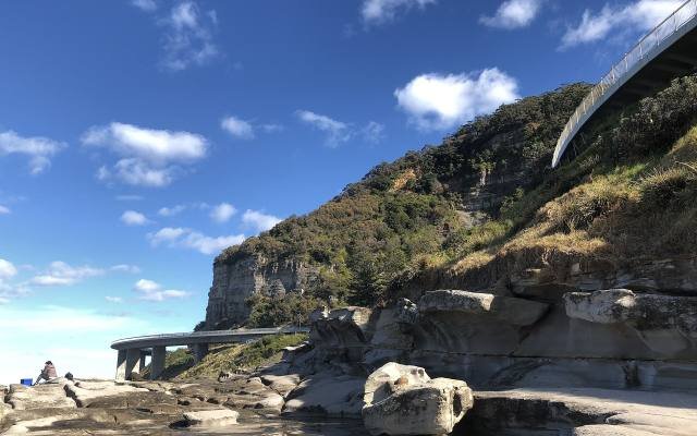 The curving Sea Cliff Bridge on the Grand Pacific Drive above a rocky shore