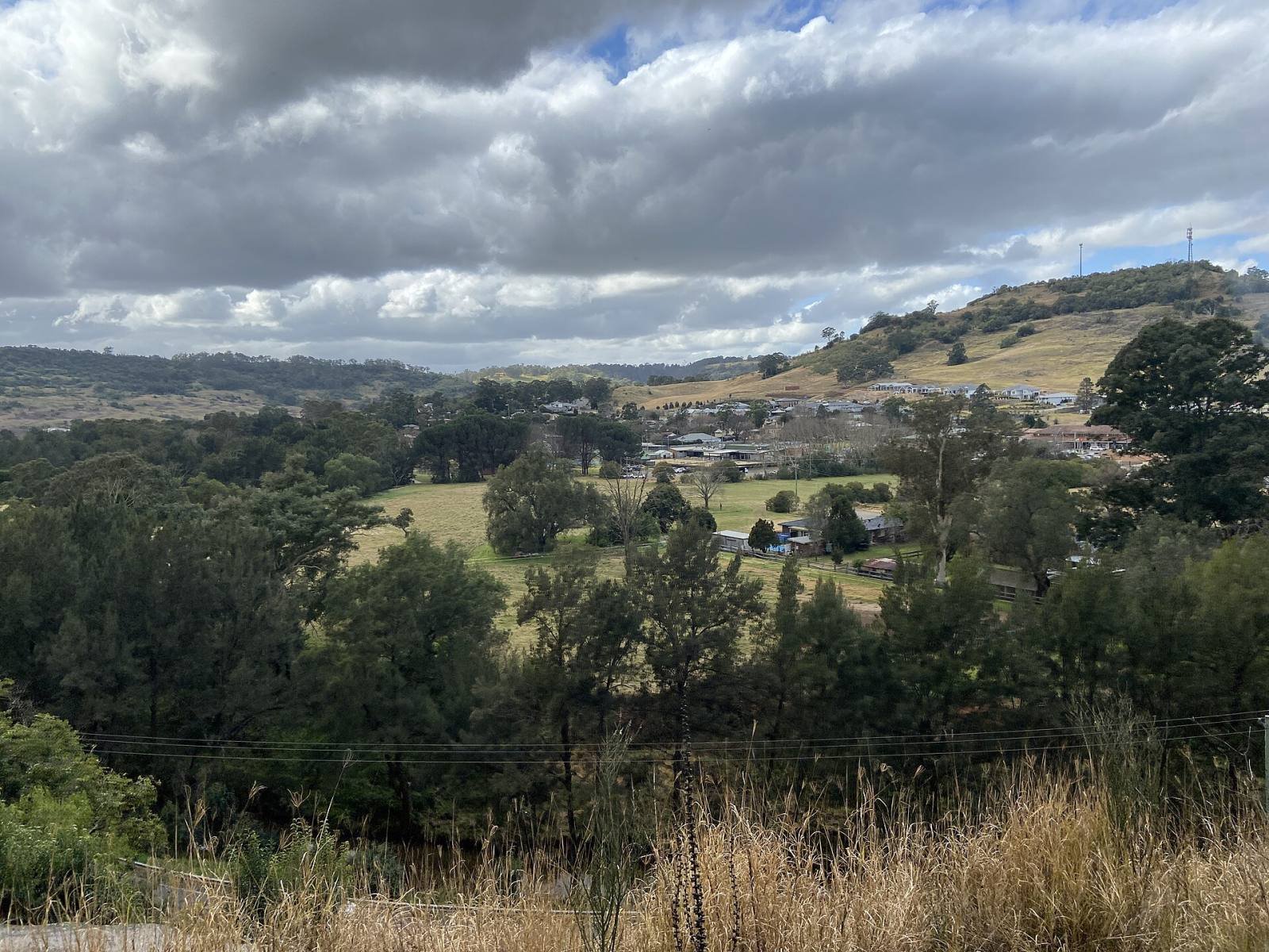 The village of Picton among green hills under a cloudy sky
