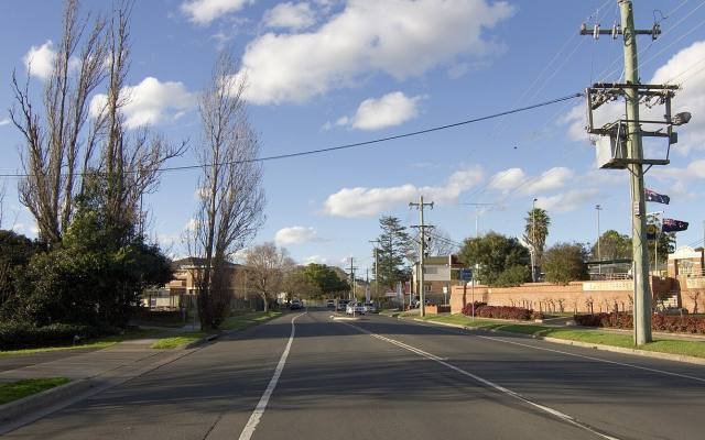 A tree-lined street in Camden under a blue sky